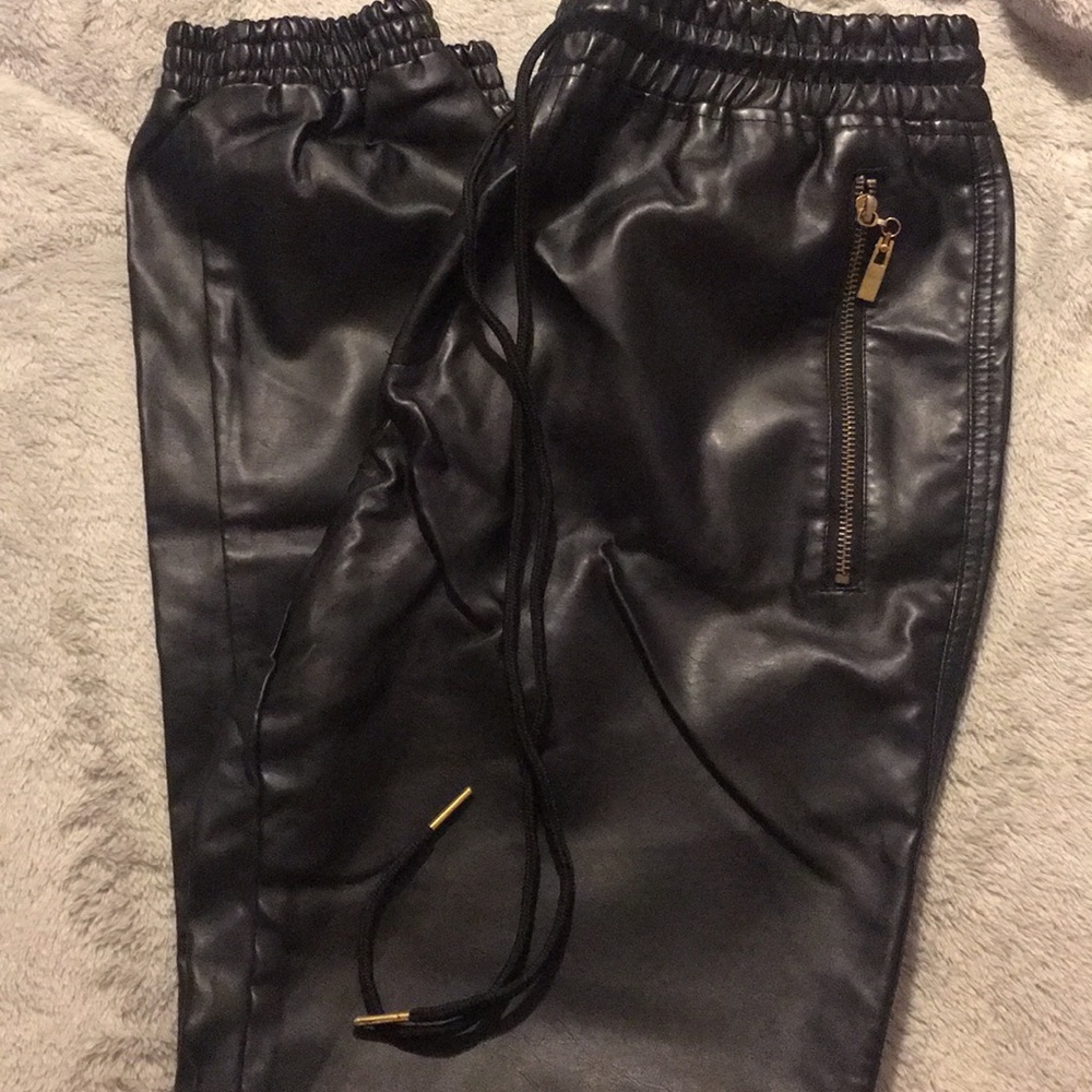 Black faux leather joggers with gold zippers